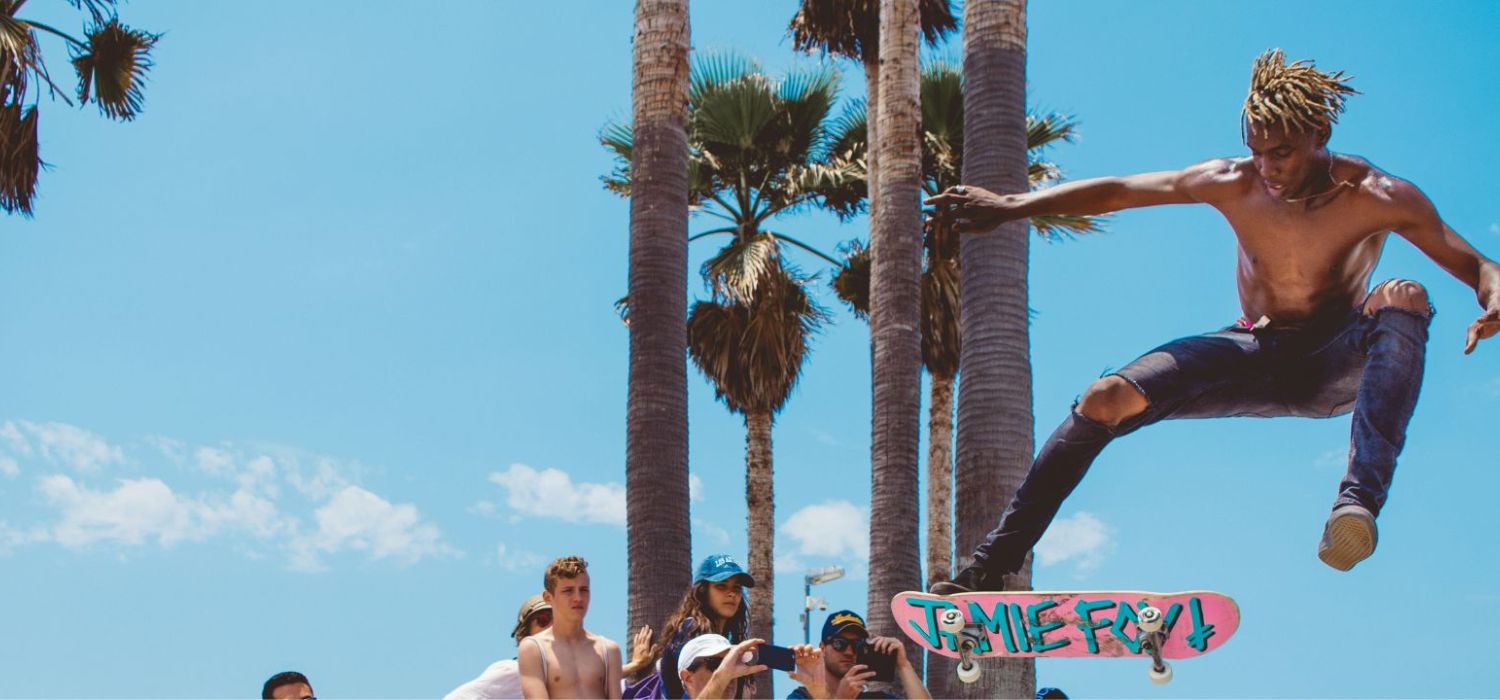 muž na skateboardu předvádí triky před lidmi, kteří si ho fotí