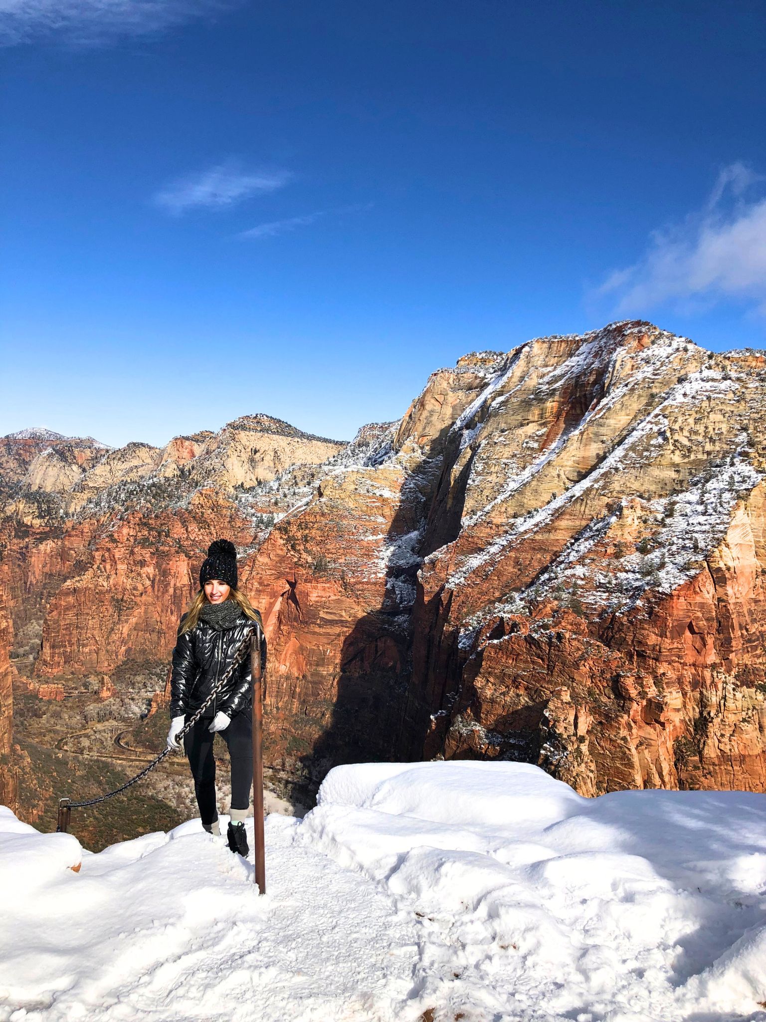 žena stojí na vrcholu Angels Landing v národním parku Zion