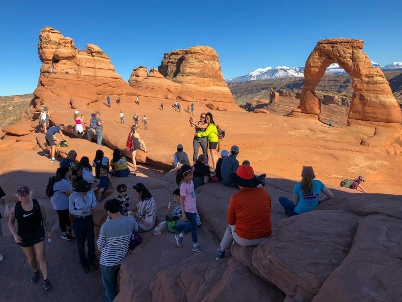 Davy lidí kolem Delicate Arch v Arches NP.