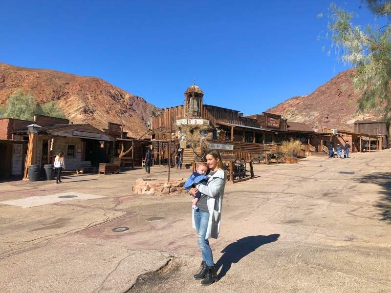 Žena s dítětem pózuje před dřevěnou restaurací v Calico.