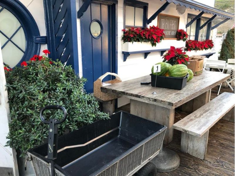 bílomodrý dům na Malibu Pier zdobený vánoční hvězdou, s dřevěným stolem a melouny