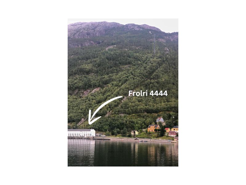 Bílá budova Flørli u vody pod kopcem