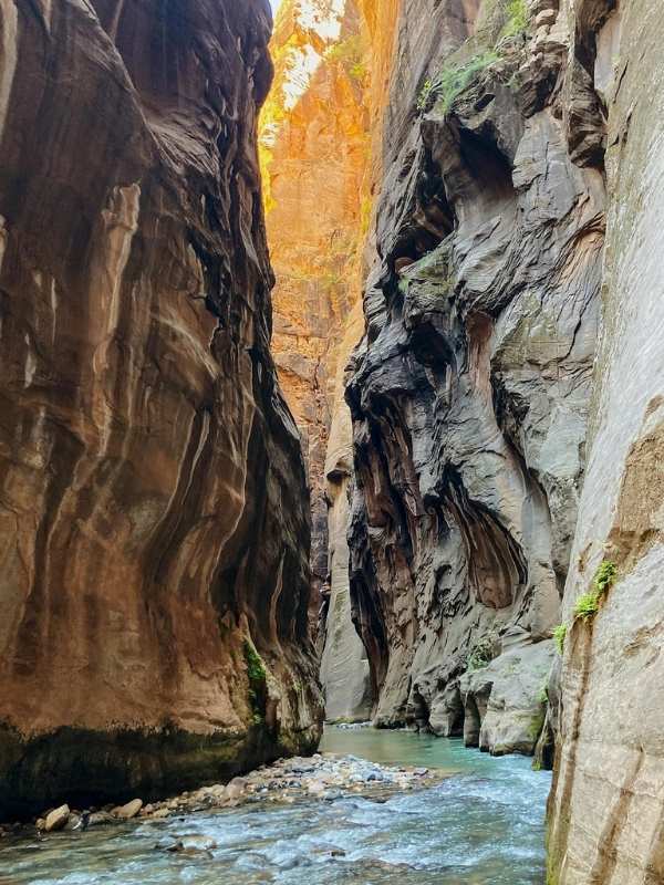 Hiking in Zion NP kaňon se zužuje, světlo proniká škvírou a voda je čistá v národním parku Zion