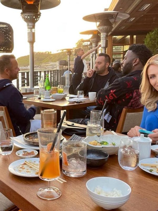 záběr z restaurace, stůl plný jídla a nádobí, u stolu sedí známý zpěvák Jason Derulo