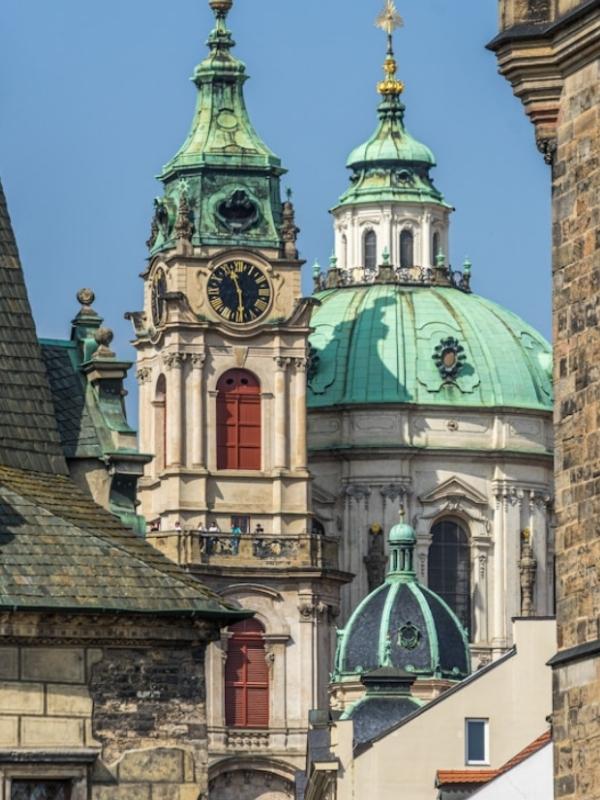 Kostel se zelenou střechou na pozadí oblohy