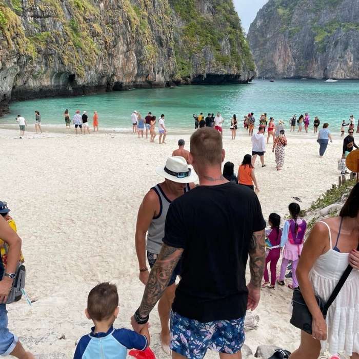 Muž s chlapečkem přichází na Maya Bay plnou turistů
