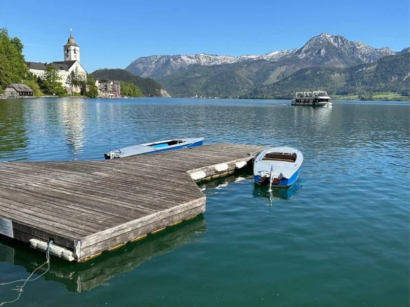 Molo s malou loďkou, v dálce kostel v Rakousku