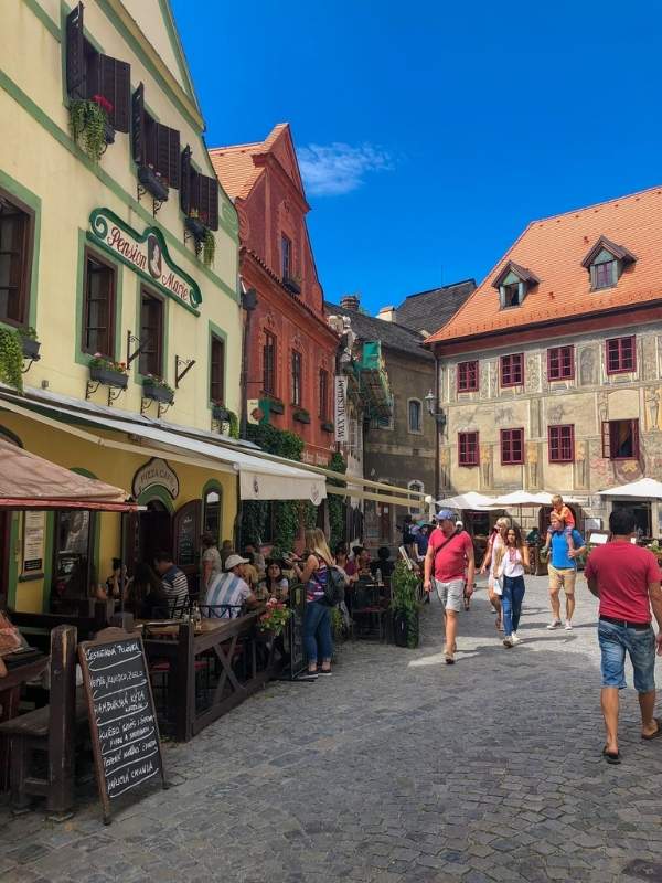 Náměstí v Českém Krumlově s venkovní restaurací a stolky na terase