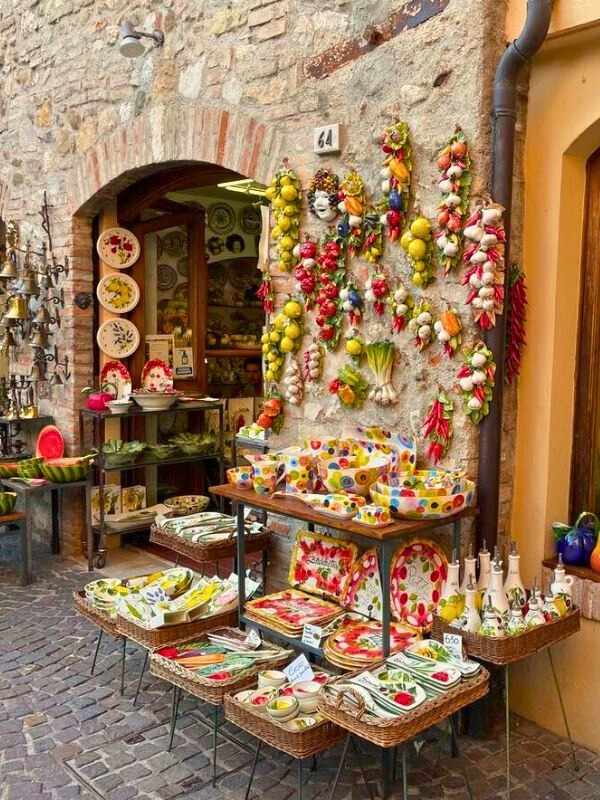 Barevný obchůdek vystavuje své zboží venku – barevný porcelán a atrapy zeleniny.**