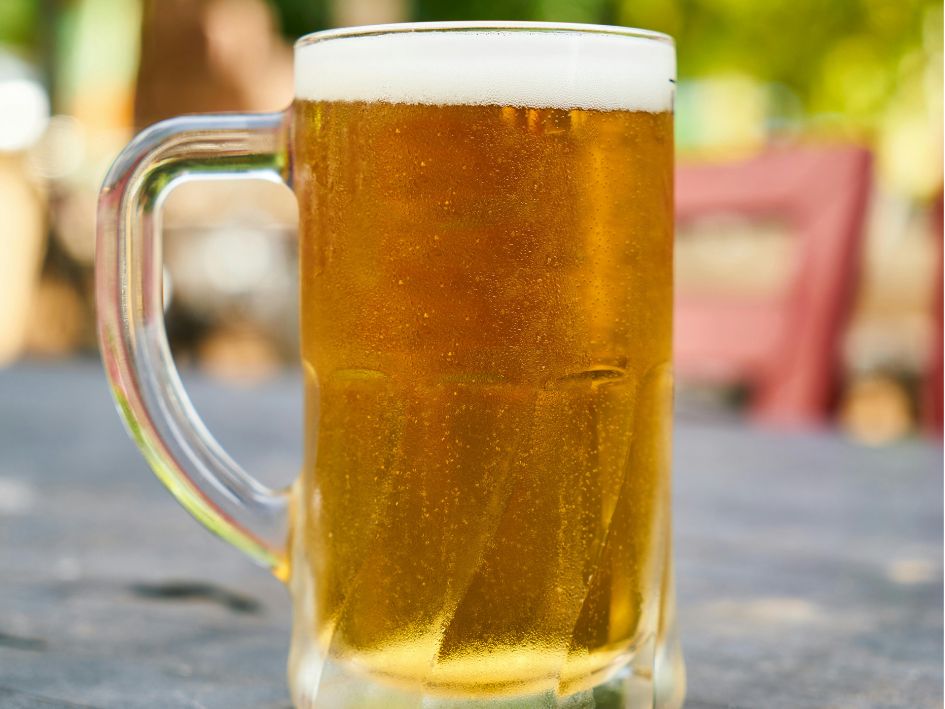 Orosená sklenice piva stojící na stole