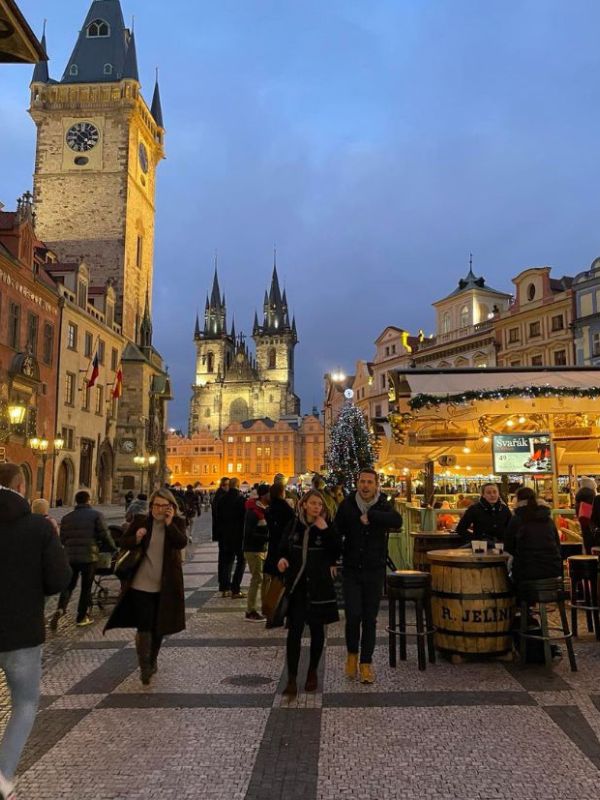 Vánočně ozdobené Staroměstské náměstí s nasvícenými dekoracemi a lidmi v kabátech