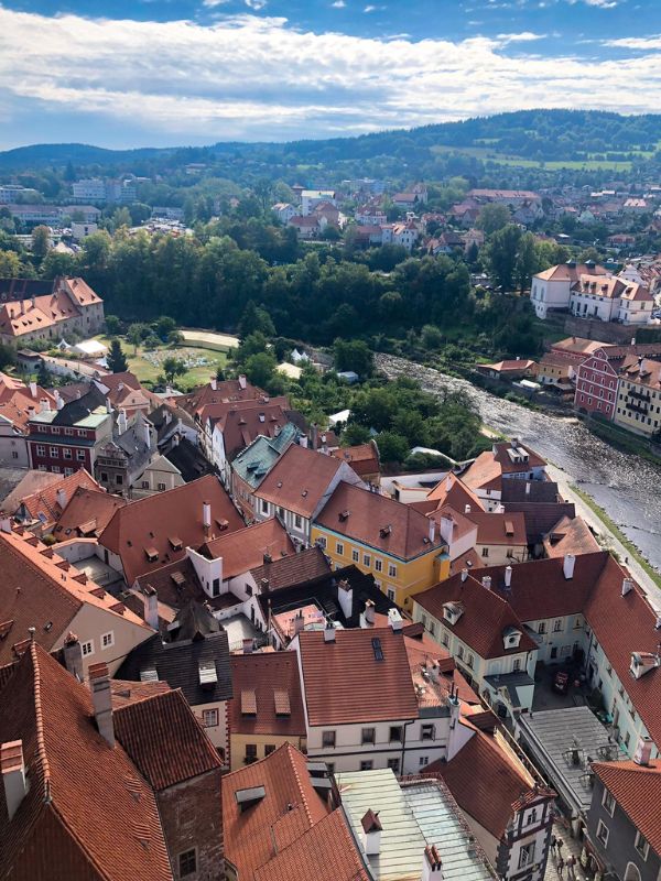 Letecký pohled na most v Českém Krumlově s budovami s červenými střechami kolem