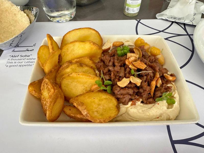 Vegan veganská kuchyně v Abú Dhabí, talíř s bramborami, hummusem a náhradou masa