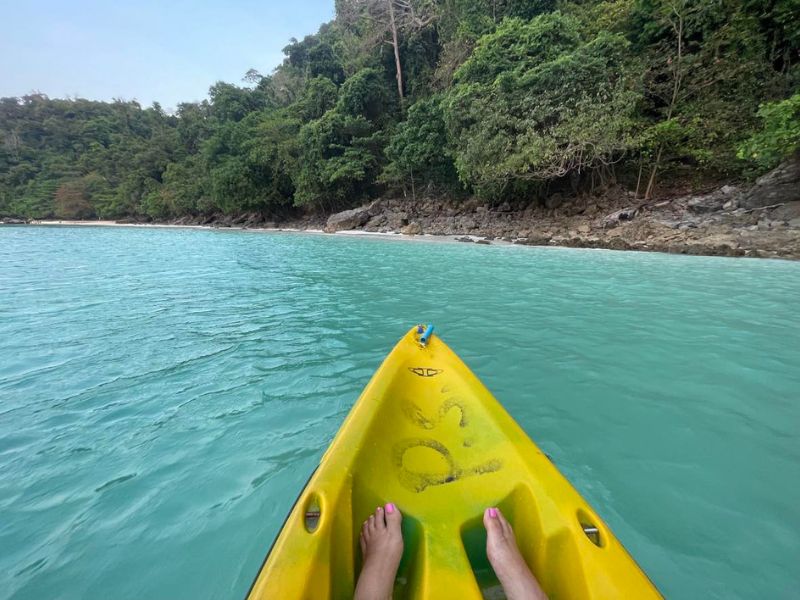 Kousek žlutého kajaku plujícího v čisté modré vodě