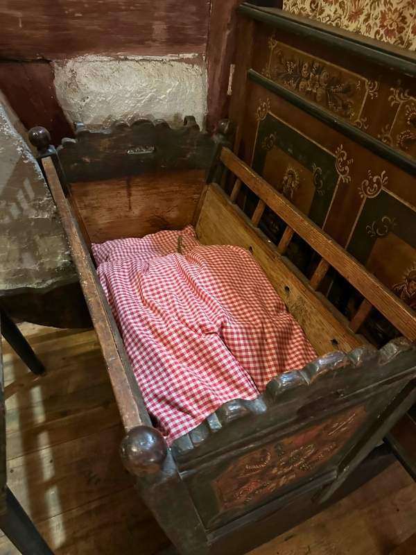 starodávná kolébka s červenobílými peřinkami