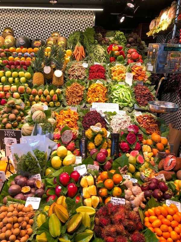 Ovoce, zelenina a květiny vystavené na venkovním trhu v Barceloně.