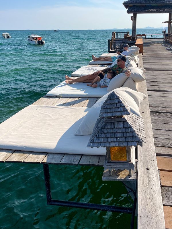 Venkovní postele podél mola s výhledem na oceán.