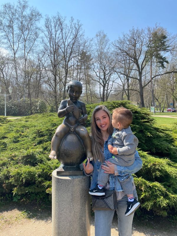 Žena se synem pózují před bronzovou sochou Františka ve Františkových Lázních.