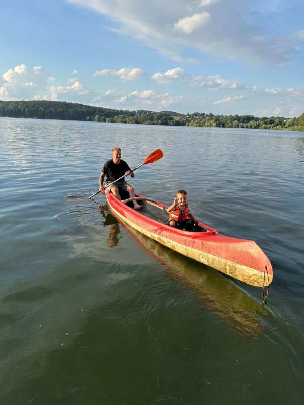 Muž a chlapec ve vestě na kánoi.
