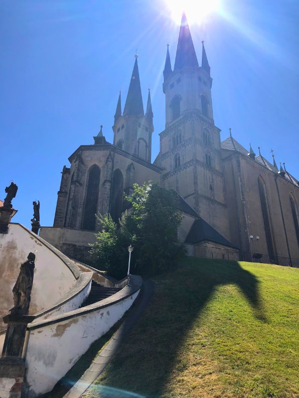 Kostel s věžičkami v Chebu pod modrou oblohou.