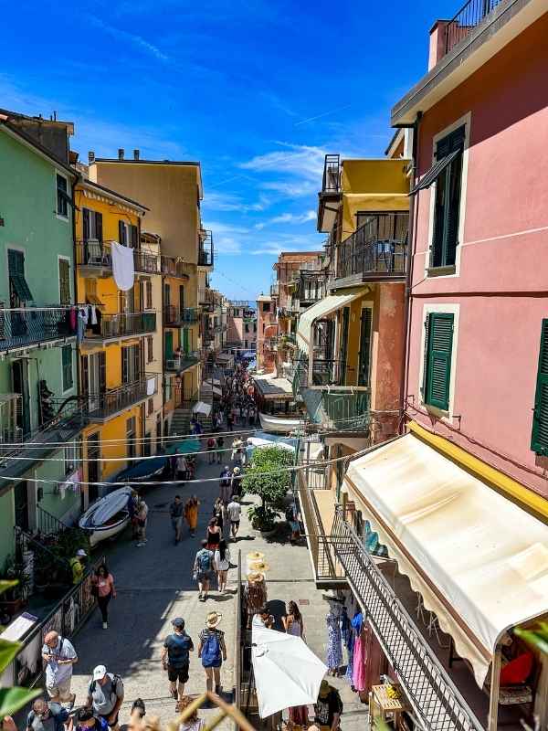 ulice v Corniglia s barevnými domky a lidmi procházejícími středem