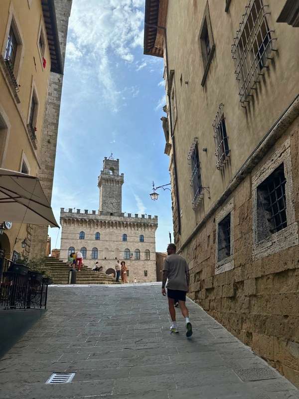 Věž v Montepulcianu, muž kráčí směrem k náměstí.