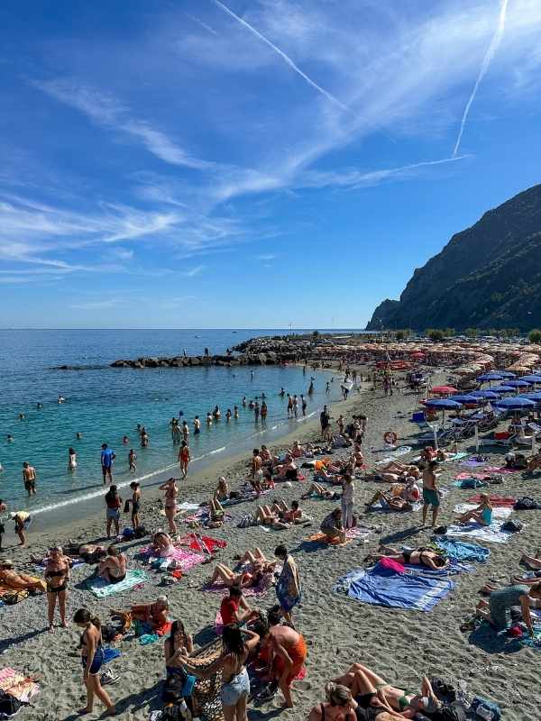 pláž plná lidí v Monterosso, modrá obloha