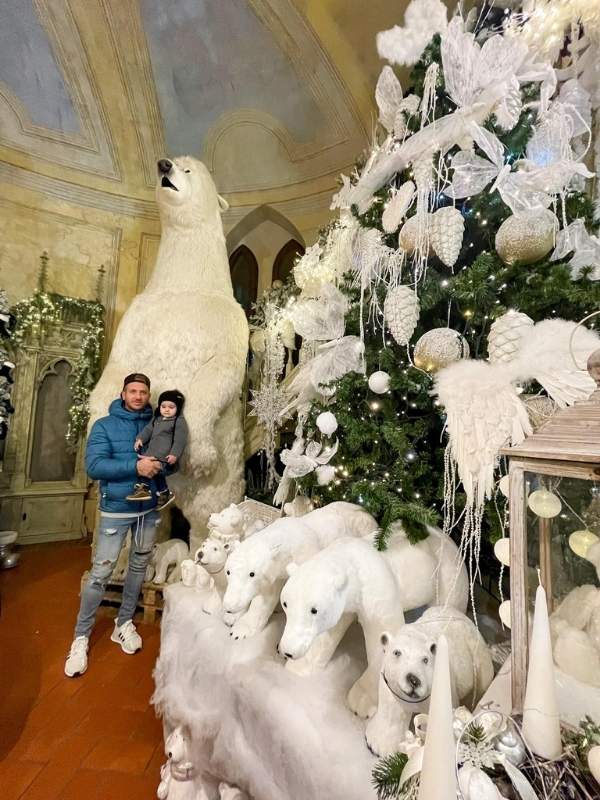 Otec a syn pózují před velkým ledním medvědem, kolem vánoční stromečky v Karlových Varech.