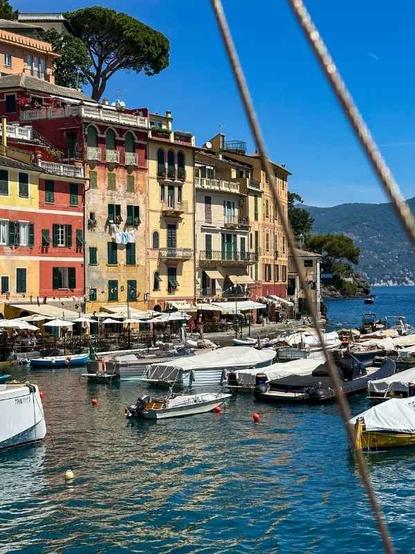lodě v přístavu Portofino v Itálii, barevné italské domky v pozadí
