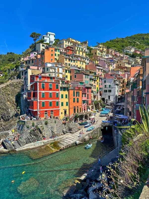 barevné domečky Cinque Terre na skalách se zelení a modrou oblohou