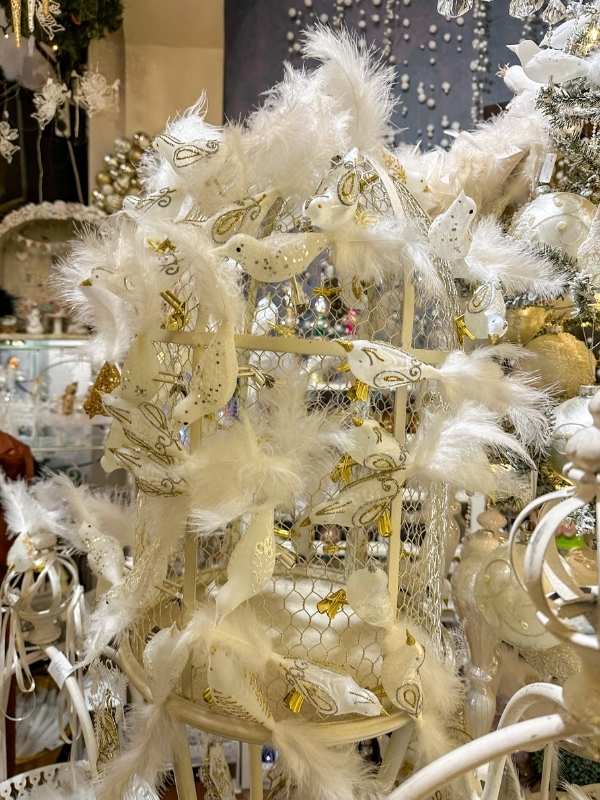 Bílé vánoční ozdoby ptáčků s peřím.