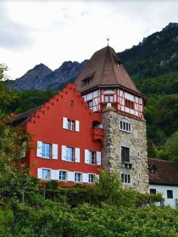 Červený domek na kopcích v Lichtenštejnsku.