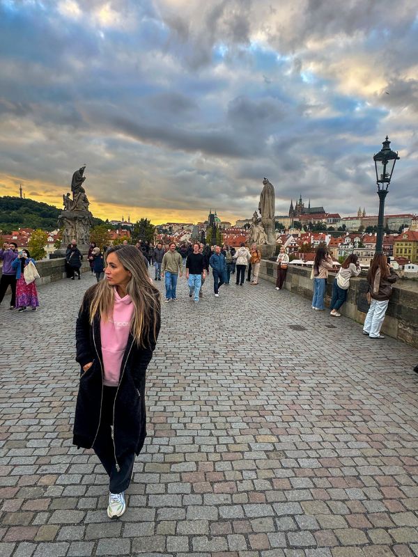 Žena jde po Karlově mostě a napodobuje scénu z videoklipu *Numb* od Linkin Park.