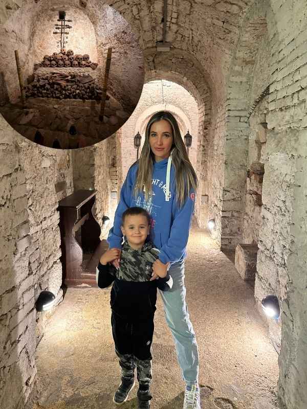 Hrníček s kávou držený nad budovami Karlových Varů.