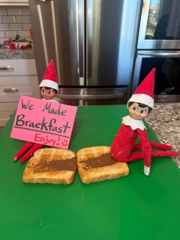 elf on the shelf Dítě s helmou si hraje s malou bronzovou soškou připomínající myš za slunečného dne. V pozadí jsou vidět stromy a kulatá věž.