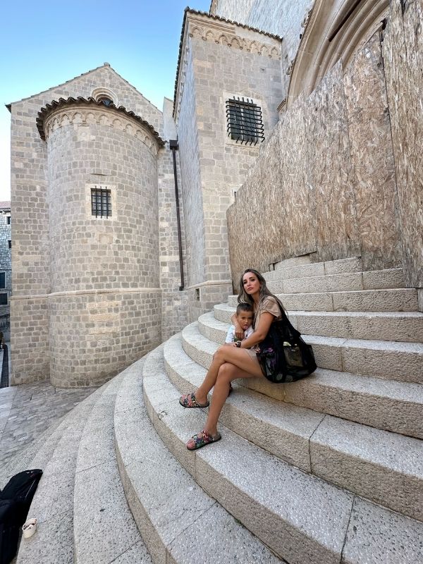 Chorvatsko, Dubrovnik Žena s dítětem sedící na kamenných schodech v historickém centru Dubrovníku, Chorvatsko.