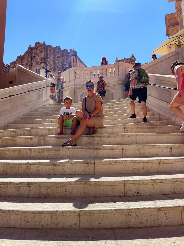 Dubrovnik Croatia Pokračujeme 👌 tady máš alt text k téhle fotce z Dubrovníku: Popisný / SEO: „Žena s dítětem sedící na kamenných schodech v historickém centru Dubrovníku, Chorvatsko.