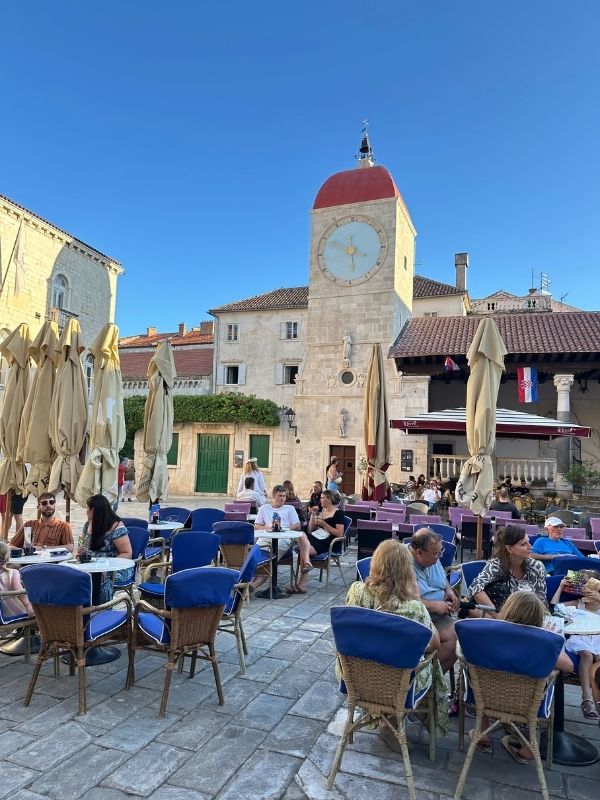 Trogir Hlavní náměstí v Trogiru s historickou hodinovou věží a kavárnami, Chorvatsko.